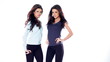 Two Brunette Girls in Casual Clothes Posing Isolated on White