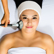 Foto: Cosmetics - Asian woman gets a facial mask Cosmetics - Asian woman gets a facial mask