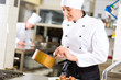Photo: Female Chef in restaurant kitchen cooking Female Chef in restaurant kitchen cooking