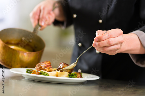 Photo: Chef in hotel or restaurant kitchen cooking Chef in hotel or restaurant kitchen cooking