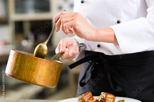Photo: Female Chef in restaurant kitchen cooking Female Chef in restaurant kitchen cooking