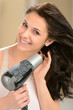Happy girl blow drying her hair