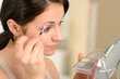 Young girl applying eyeshadow looking at mirror
