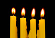 Yellow candles isolated on black background
