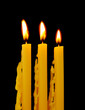 Yellow candles isolated on black background
