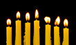 Yellow candles isolated on black background