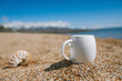 espresso coffee cup  on the issyk-kul beach sand with mountains