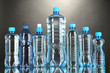 Different water bottles on grey background