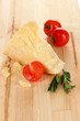 Piece of Parmesan cheese on wooden table close-up