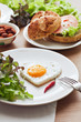 Fried egg on heart-shaped toast with salad for Valentine's Day