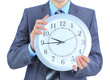 Photo: A young businessman with a wall clock. A young businessman with a wall clock.