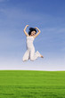 Foto: Beautiful woman jump on green field Beautiful woman jump on green field