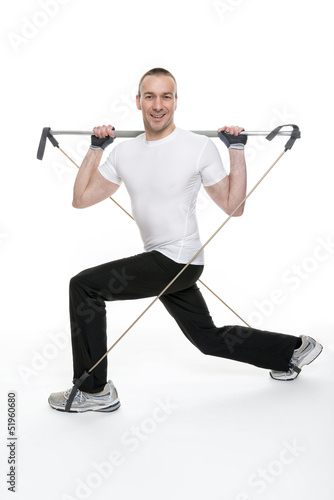 Photo: Sportlicher junger Mann bei einer Gymnastikübung mit einem Gymn Sportlicher junger Mann bei einer Gymnastikübung mit einem Gymn
