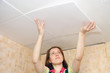Woman glues ceiling tile