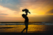 Silhouette of a pregnant woman with her daughter at sunset