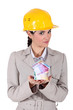 Foto: Female architect holding house lade from bank notes Female architect holding house lade from bank notes