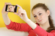 Foto: Teenager nimmt Selbstportrait mit Smartphone auf Teenager nimmt Selbstportrait mit Smartphone auf