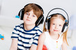 Brother and sister listening music with headphones