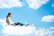 Photo: young girl running in the clouds with a laptop young girl running in the clouds with a laptop