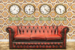 Retro chesterfield sofa with world time clocks on a wall