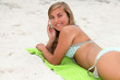 Foto: portrait of a young woman on the beach with phone portrait of a young woman on the beach with phone