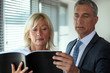 Senior business couple reading through contract