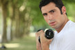 Foto: Man with weights in a field Man with weights in a field