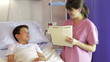 Female Doctor Talking To Boy In Hospital Bed