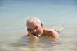 Foto: Grey-haired man laying in the sea Grey-haired man laying in the sea