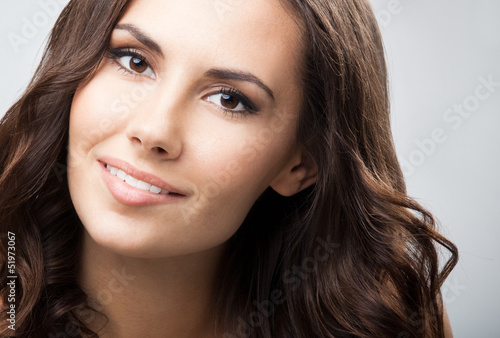 Photo: Portrait of beautiful woman, over grey Portrait of beautiful woman, over grey
