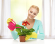 housewife with flower in pot and watering can