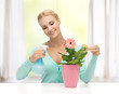 woman holding pot with flower and spray bottle