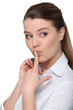 Photo: Portrait of a cheeky businesswoman with her finger on her lips Portrait of a cheeky businesswoman with her finger on her lips