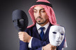 Arab with masks in dark studio