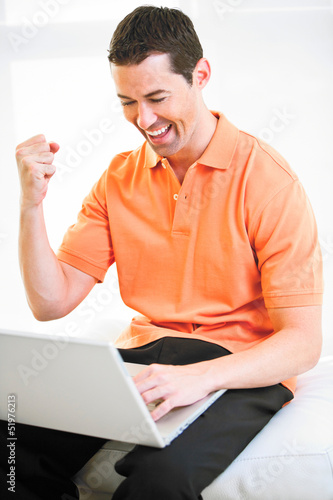 Photo: Happy work at home male working on laptop smiling Happy work at home male working on laptop smiling