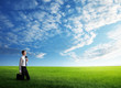 Photo: young business man wolking at the field of grass young business man wolking at the field of grass