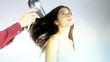 Hairdresser drying long hair of model