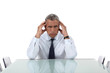 Photo: Senior business sat alone in meeting room Senior business sat alone in meeting room