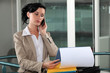 businesswoman talking on her cell and looking at her agenda