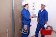 Electricians in front of electrical panel
