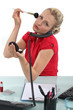 Woman putting her makeup on in the office