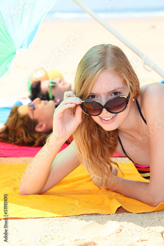 Photo: Teens tanning on the beach Teens tanning on the beach