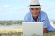 Photo: Senior man lying on the grass with a computer Senior man lying on the grass with a computer