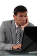 Perplexed man looking computer
