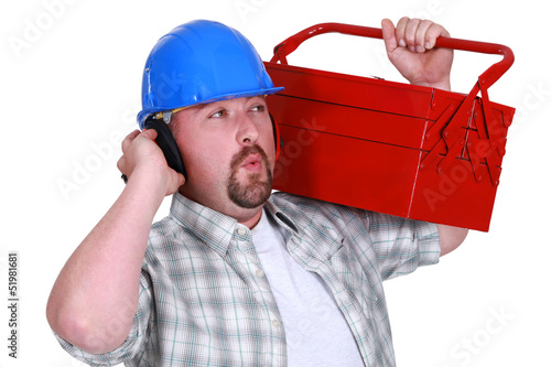 Photo: craftsman wearing headphones and carrying a tool box craftsman wearing headphones and carrying a tool box