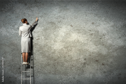 Photo: businesswoman drawing diagrams on wall businesswoman drawing diagrams on wall