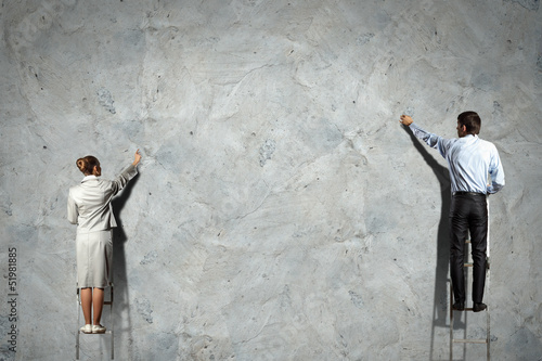 Photo: businesspeople drawing diagrams on wall businesspeople drawing diagrams on wall