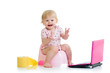 baby girl sitting on chamberpot with notebook