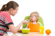 mother spoon feeding her baby girl