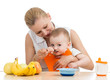mother spoon feeding baby boy